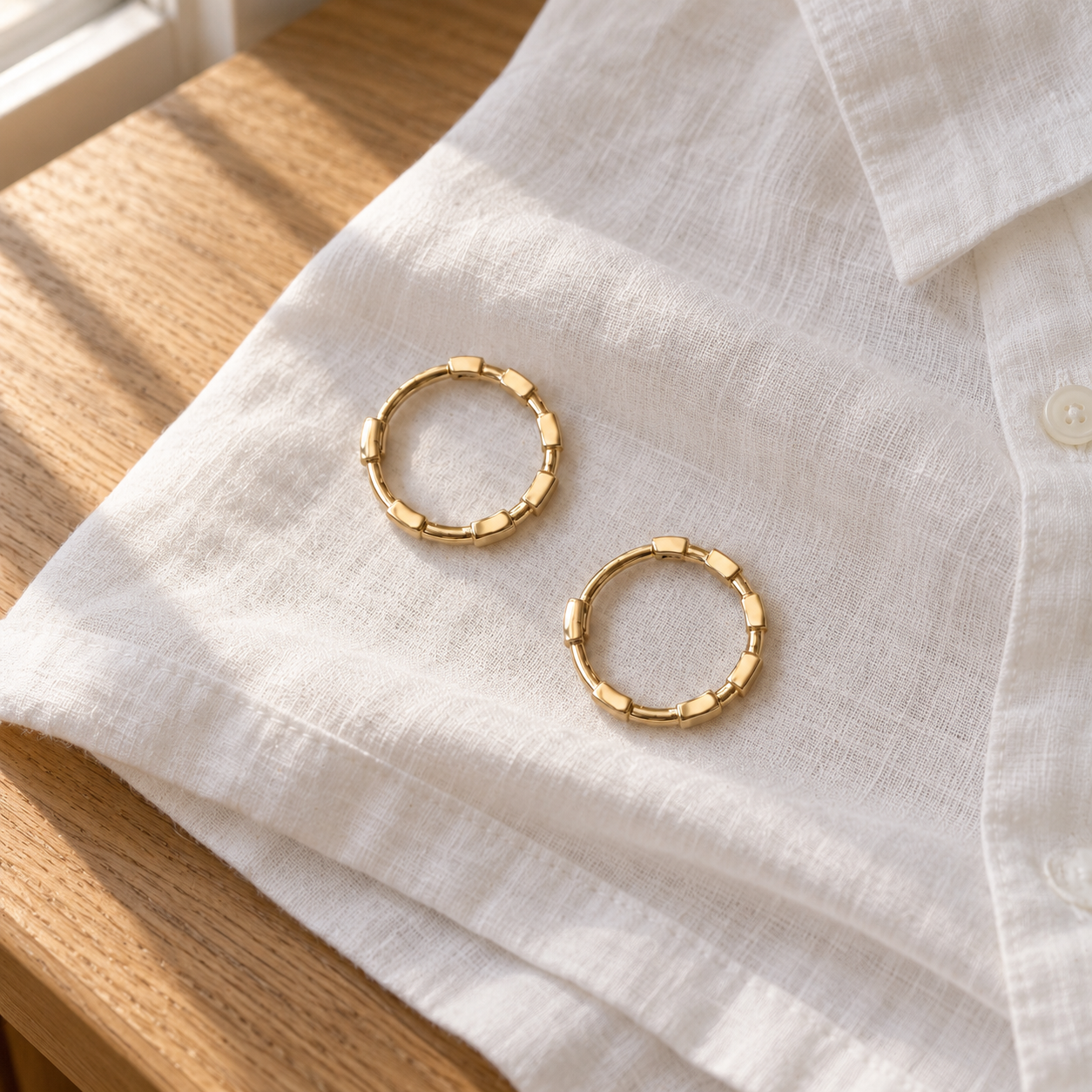 Closed Cora Bamboo Hoops resting on folded white linen; shirt not included