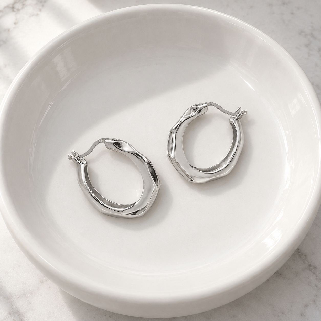 Mabel Sculpted Hoops resting in a white ceramic basin; basin not included