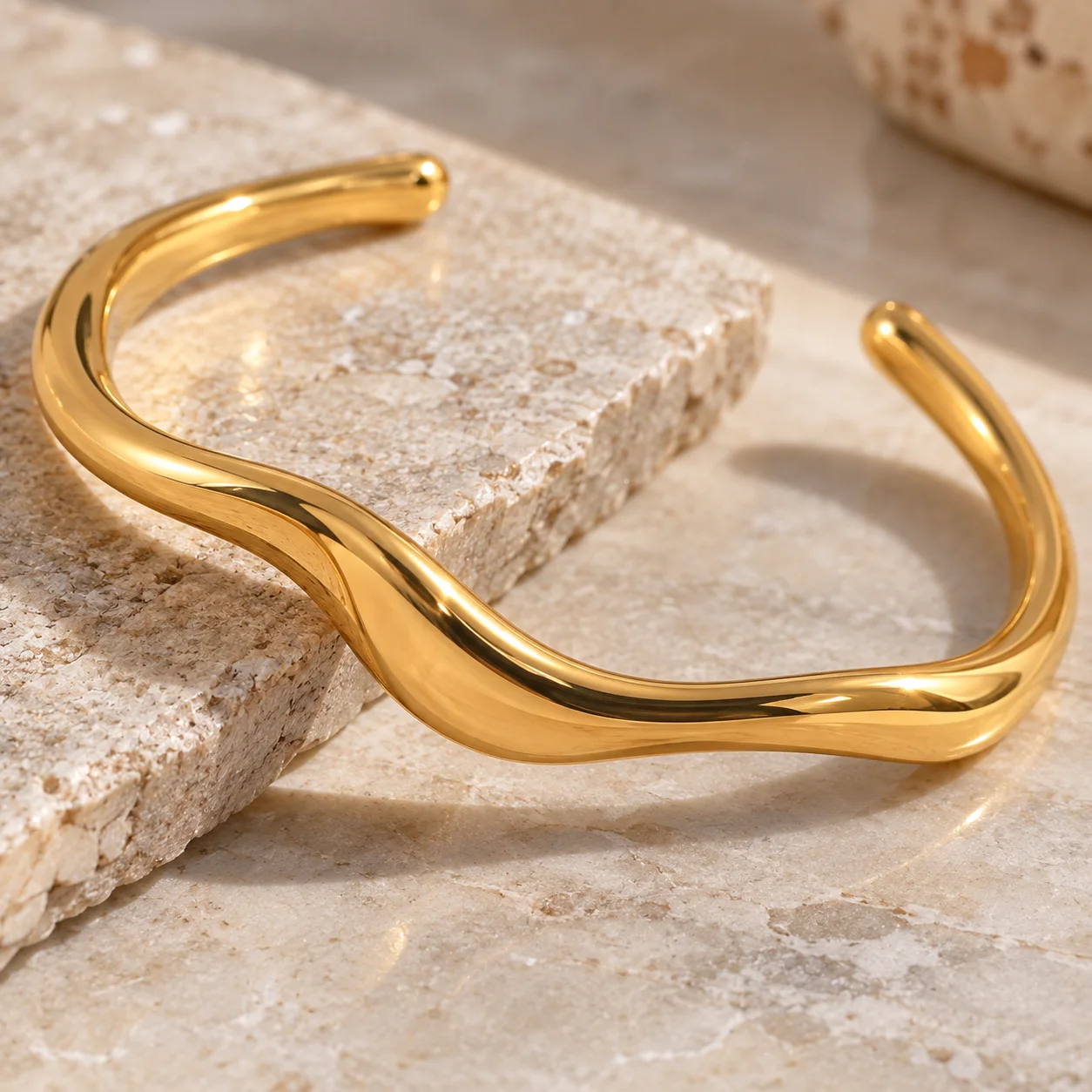 Gold-colored narrow wavy open stainless steel cuff JDB2405015: detail view; other styling items not included