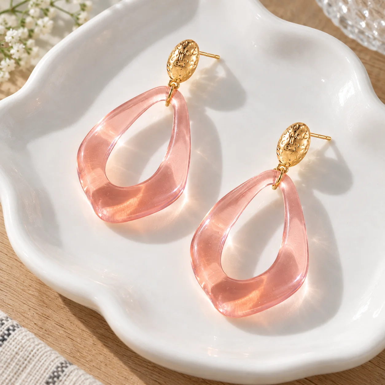 Pink transparent open teardrop earrings with textured gold oval studs: alternate view; other styling items not included