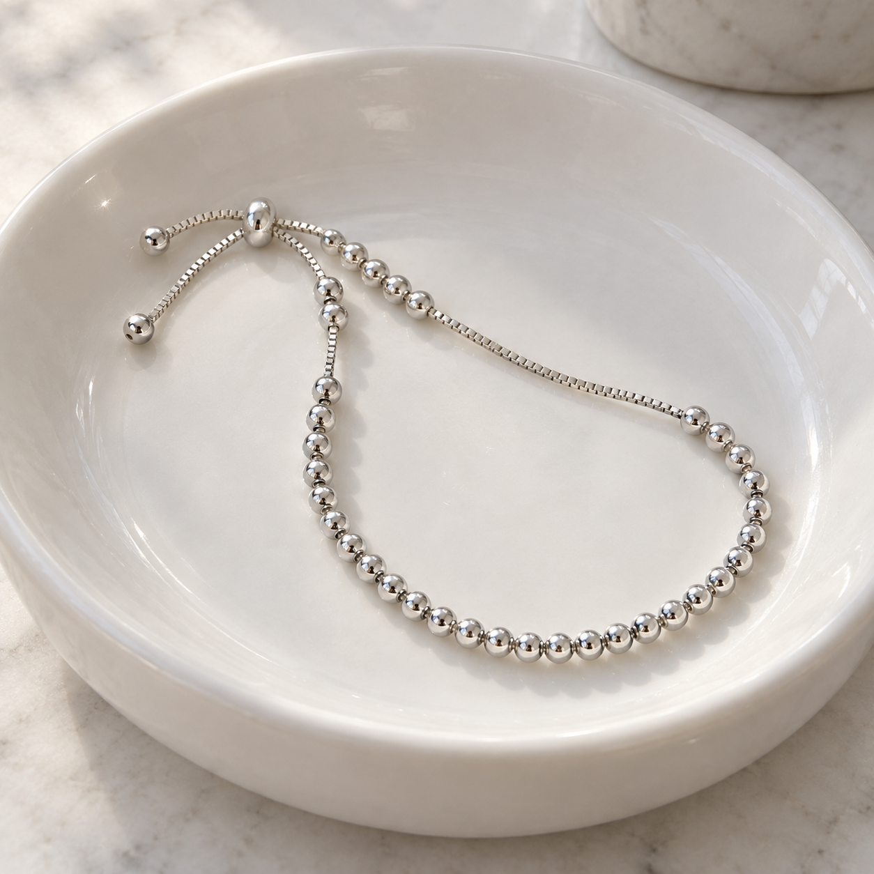 Sylvie Bead Bracelet resting in a white ceramic basin; basin not included