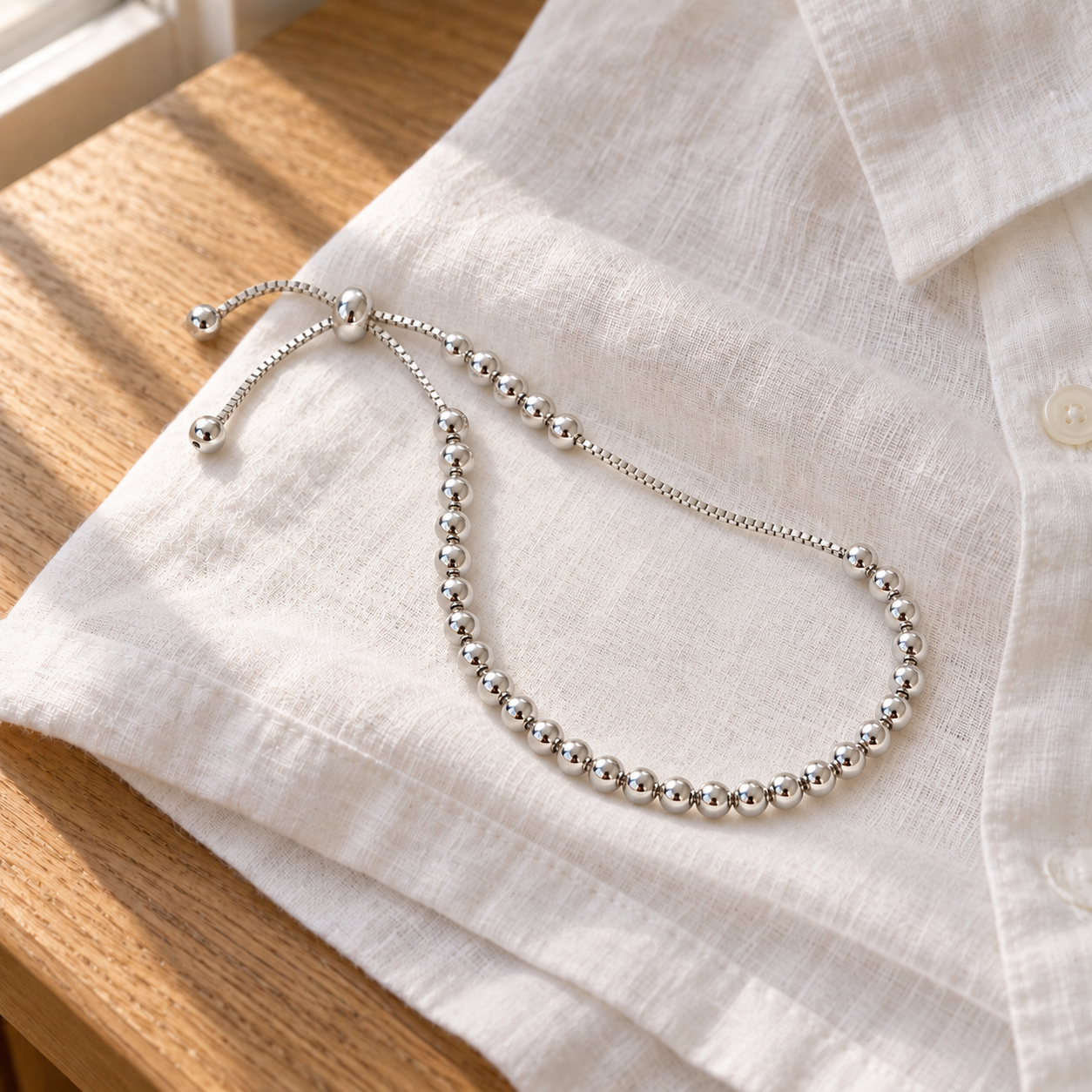 Sylvie Bead Bracelet resting on white linen; styling props not included